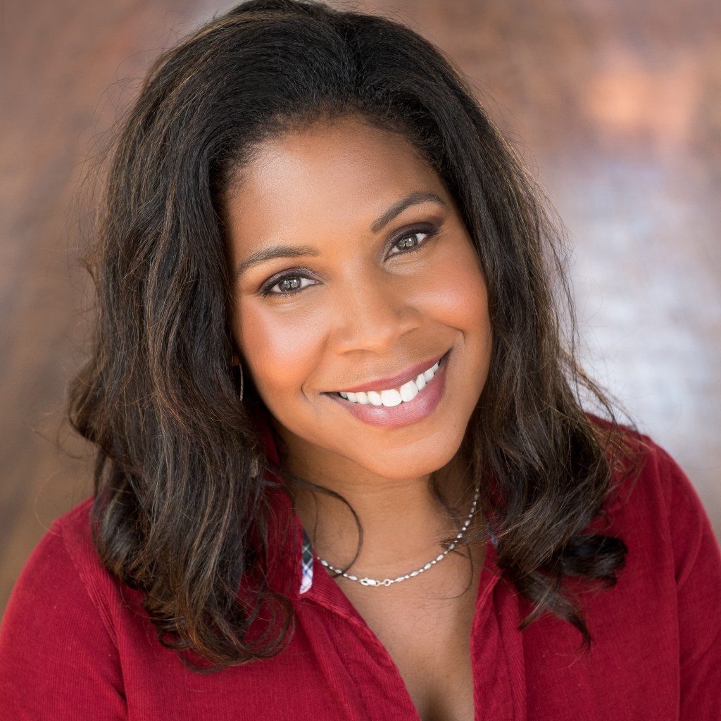 Photo portrait of award-winning best-selling author, Cerece Rennie Murphy. A beautiful Black woman with hair past her shoulders smiling warmly at the camera.